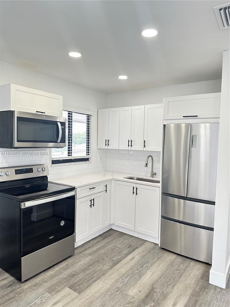 97 Northwest 73rd Place, Unit 12 Miami, FL 33126 - Photo 14 of 20 a kitchen with granite countertop stainless steel appliances and wooden cabinets
