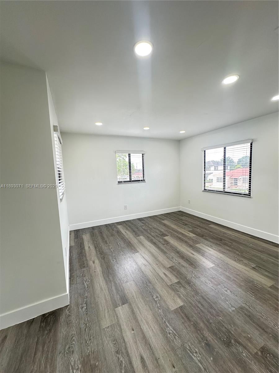 97 Northwest 73rd Place, Unit 12 Miami, FL 33126 - Photo 15 of 20 an empty room with wooden floor and windows