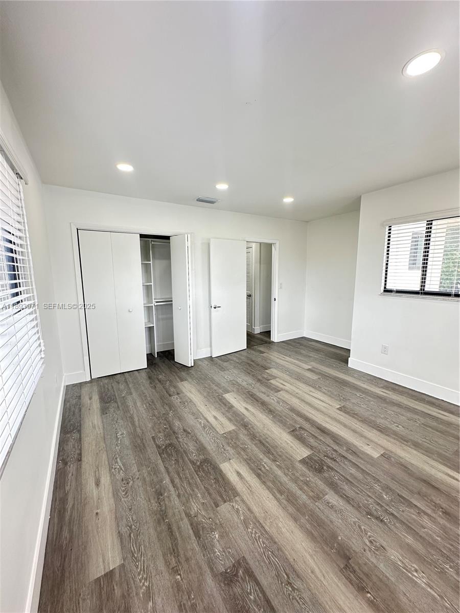 97 Northwest 73rd Place, Unit 12 Miami, FL 33126 - Photo 16 of 20 a view of empty room with wooden floor and window