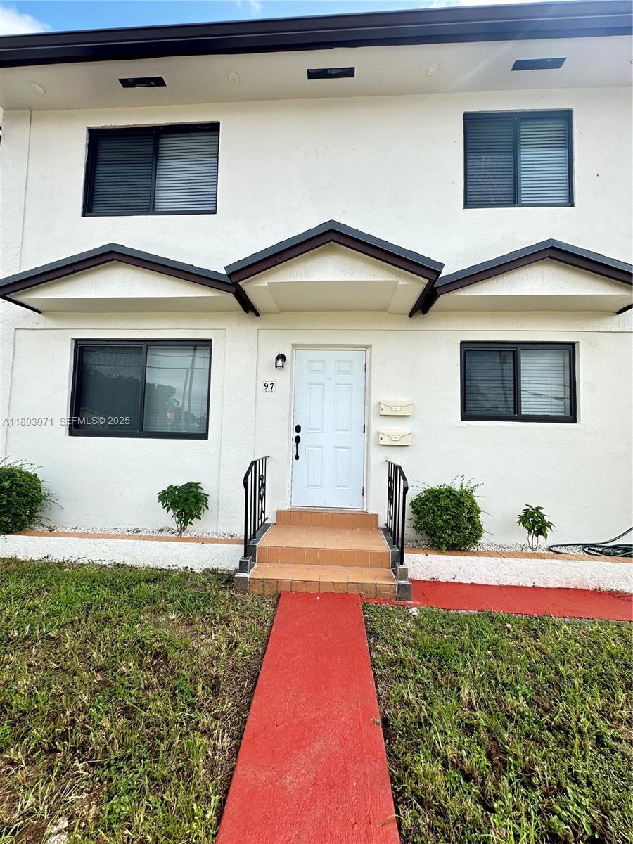 97 Northwest 73rd Place, Unit 12 Miami, FL 33126 - Photo 2 of 20 a front view of a house with a yard