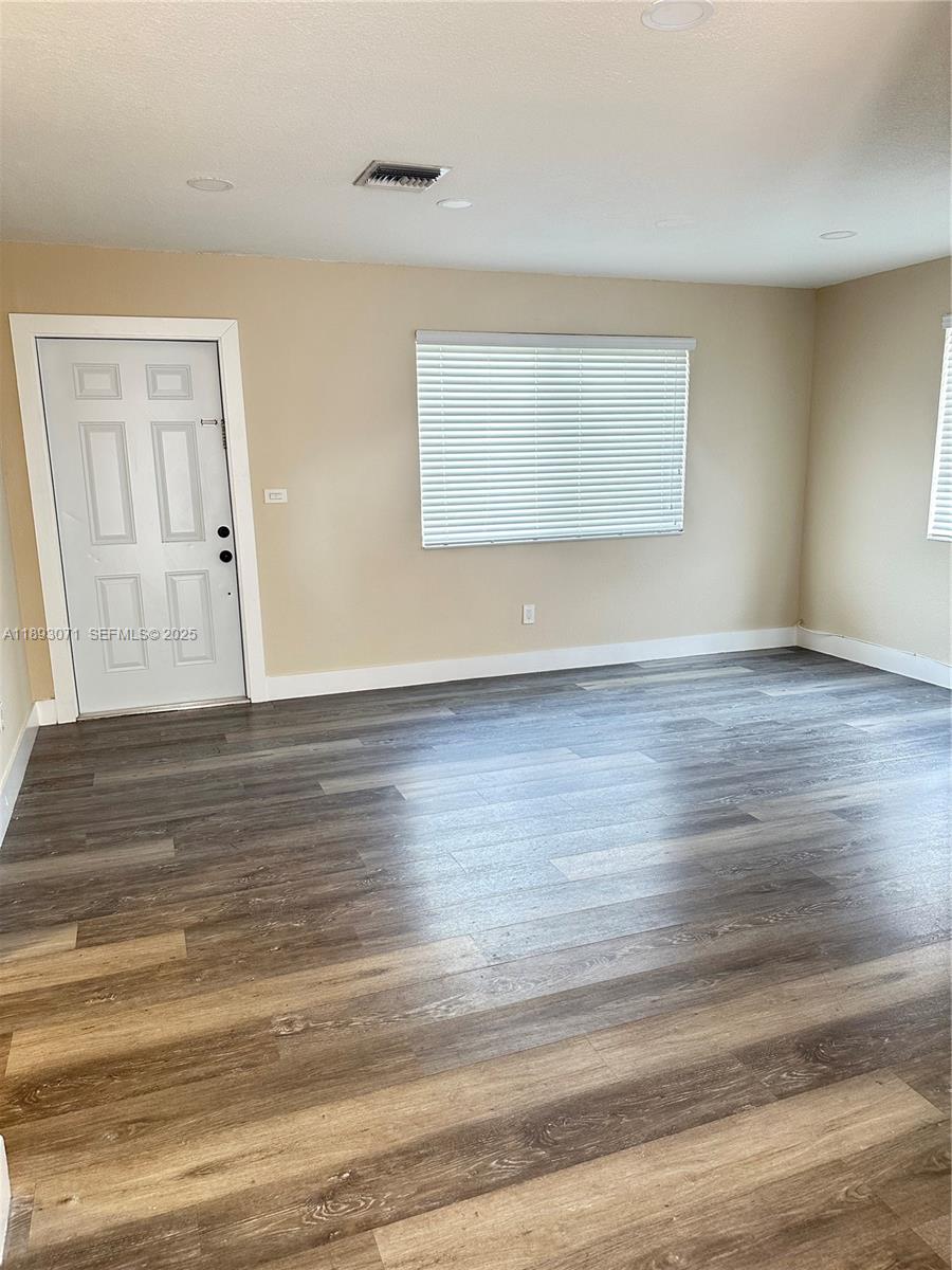 97 Northwest 73rd Place, Unit 12 Miami, FL 33126 - Photo 5 of 20 a view of an empty room with wooden floor and a window