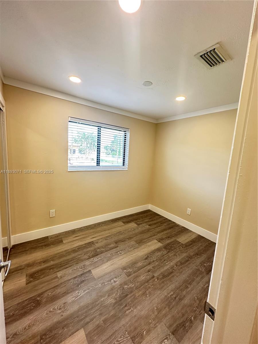 97 Northwest 73rd Place, Unit 12 Miami, FL 33126 - Photo 6 of 20 an empty room with wooden floor and windows