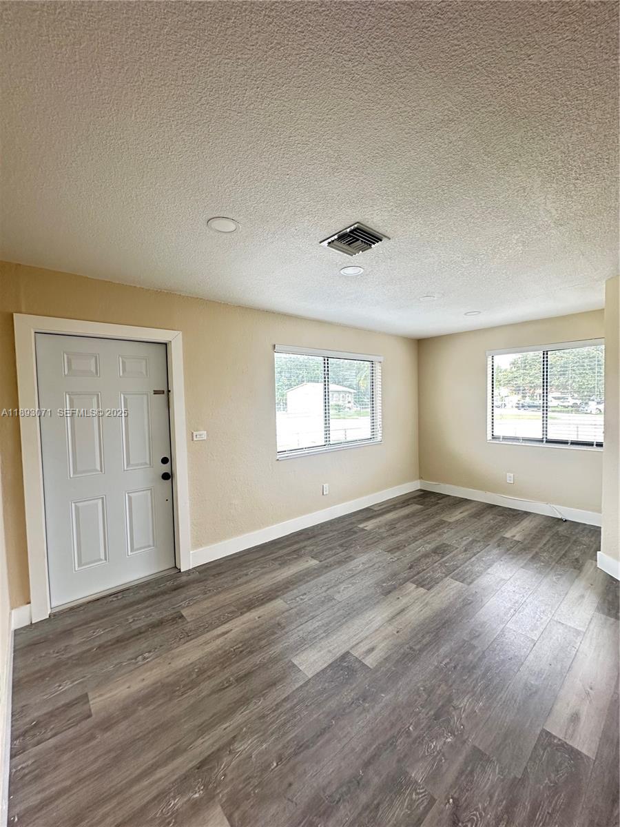 97 Northwest 73rd Place, Unit 12 Miami, FL 33126 - Photo 10 of 20 an empty room with wooden floor and windows