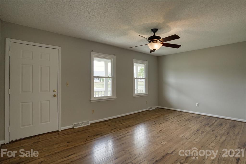 2345 Sides Road Rockwell, NC 28138 - Photo 2 of 19 an empty room with wooden floor ceiling fan with window