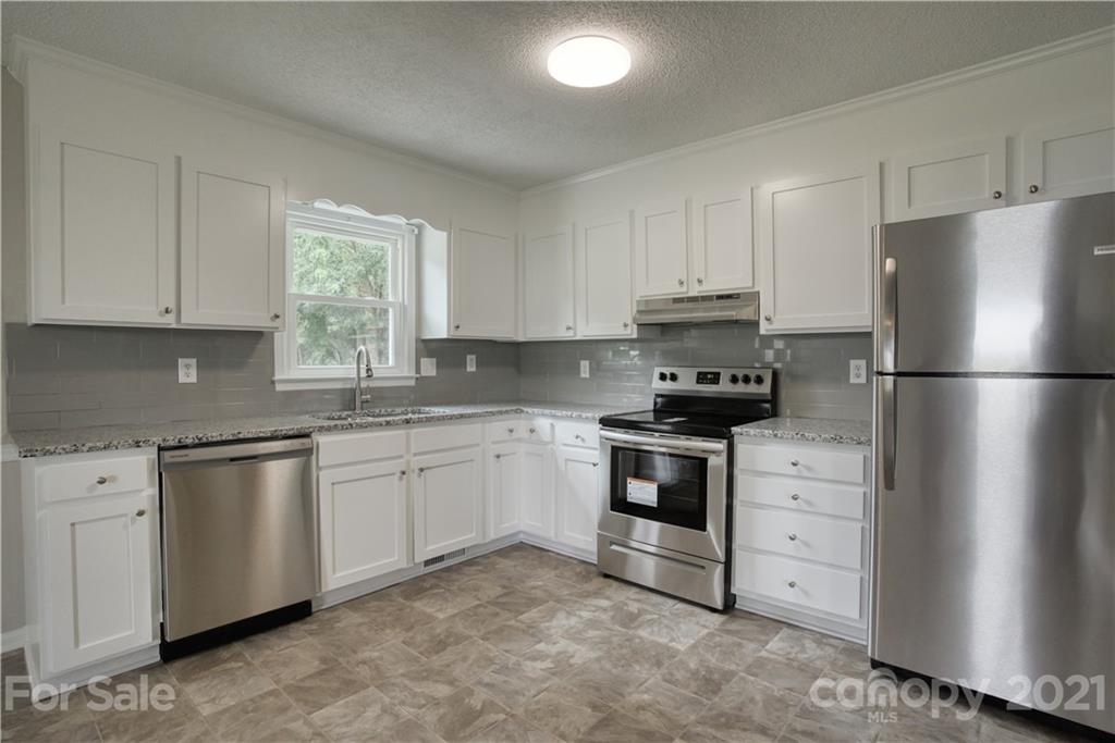 2345 Sides Road Rockwell, NC 28138 - Photo 5 of 19 a kitchen with granite countertop white cabinets and refrigerator