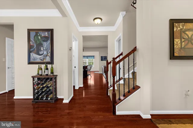 a kitchen with granite countertop stainless steel appliances a refrigerator a stove a sink a dining table and chairs with wooden floor