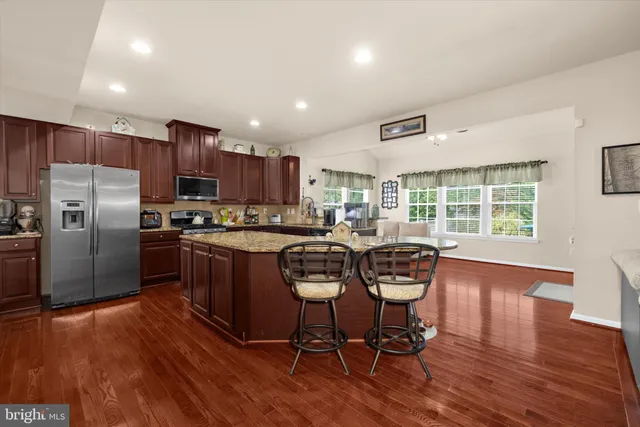 a kitchen with granite countertop wooden cabinets and stainless steel appliances