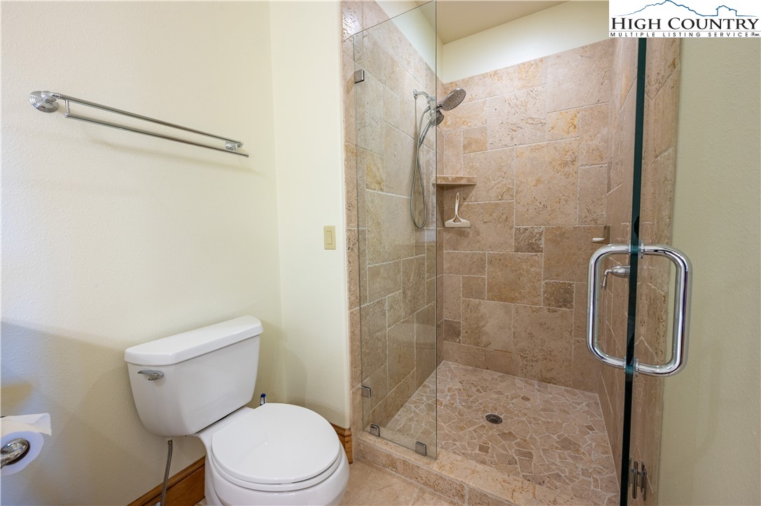 311 Penny Lane, Unit 2D Banner Elk, NC 28604 - Photo 22 of 38 a white toilet sitting next to a bath tub shower