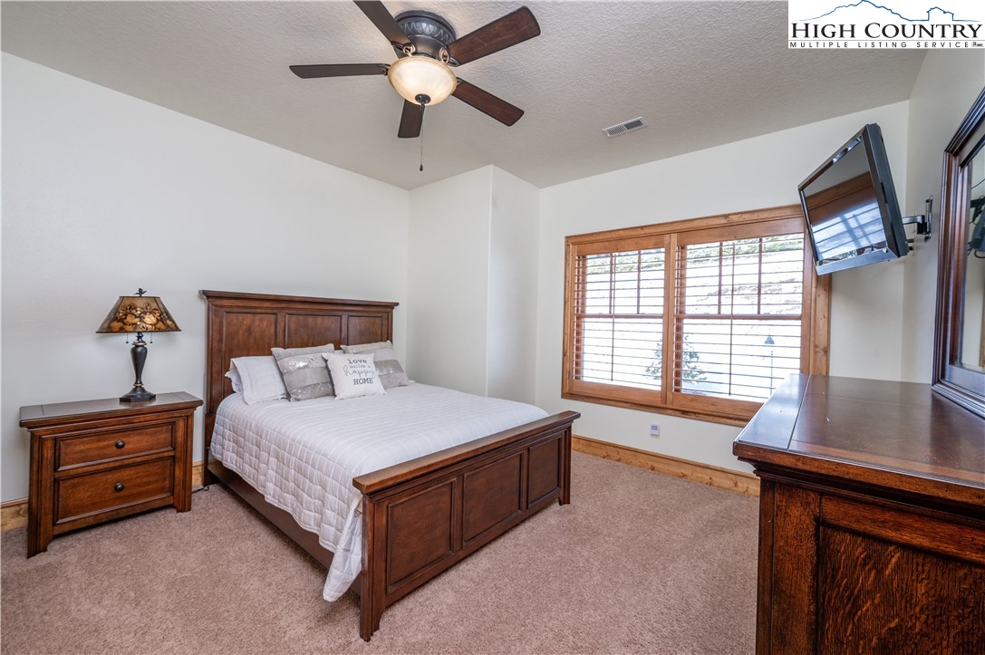311 Penny Lane, Unit 2D Banner Elk, NC 28604 - Photo 23 of 38 a bedroom with a large bed and a chandelier