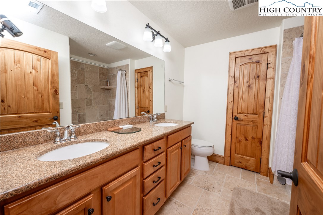 311 Penny Lane, Unit 2D Banner Elk, NC 28604 - Photo 29 of 38 a bathroom with a granite countertop sink toilet and shower