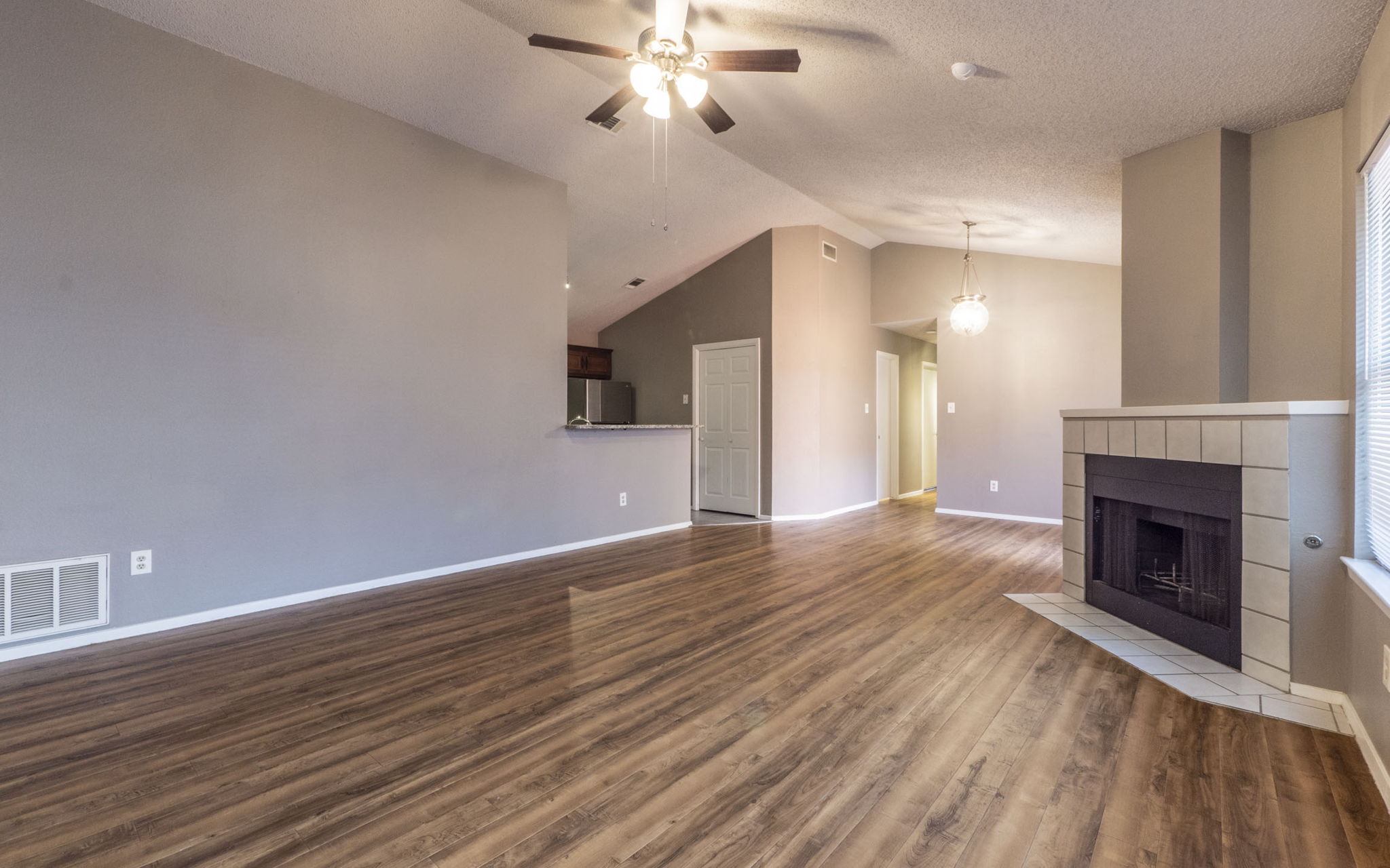 1007 Markham Lane, Unit A Austin, TX 78753 - Photo 7 of 15 a view of a livingroom with a fireplace a ceiling fan and wooden floor