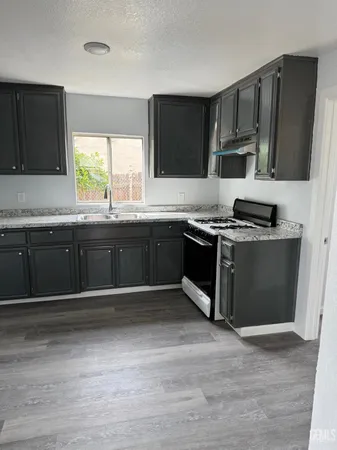 a kitchen with stainless steel appliances granite countertop a stove a sink and a microwave