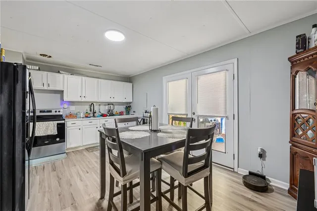 a kitchen with a table chairs refrigerator and cabinets