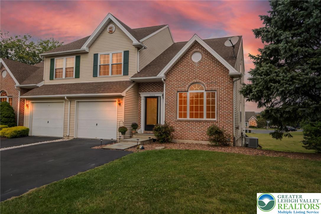 a front view of a house with a yard and trees