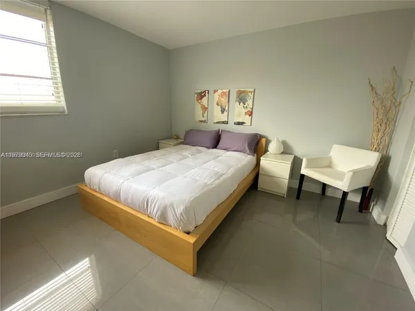 a bed sitting in a bedroom next to a window