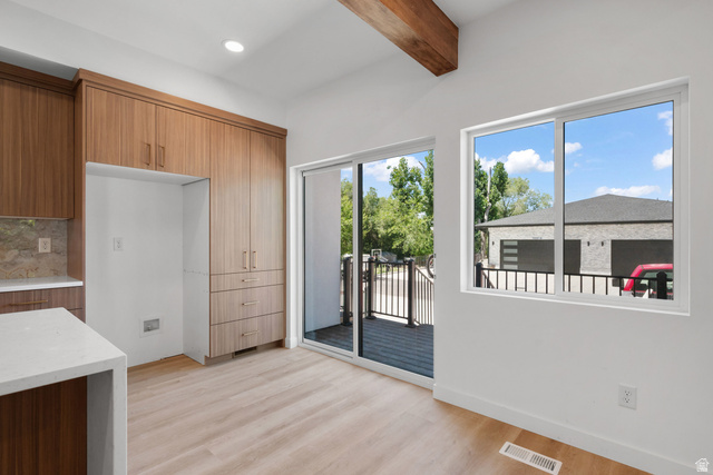 7238 South 525 East Midvale, UT 84047 - Photo 5 of 29 Open-concept living space with wood-finish flooring, a wood beam ceiling accent, and white walls