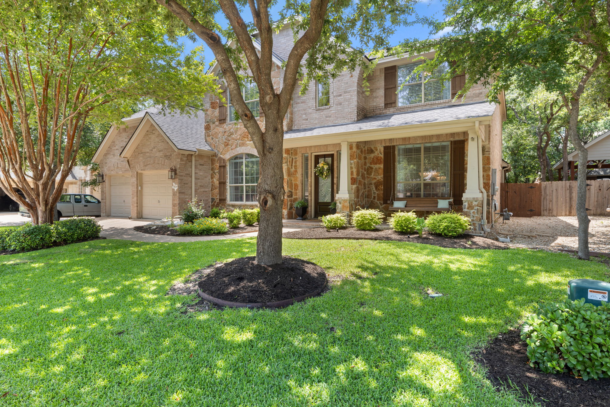 1124 Castle Path Round Rock, TX 78681 - Photo 3 of 40 A classic facade with a charming stone and brick exterior, inviting porch, and well-maintained landscaping.