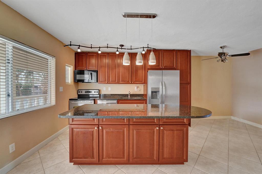 2895 Northeast 32nd Street, Unit 206 Fort Lauderdale, FL 33306 - Photo 5 of 22 a kitchen with stainless steel appliances granite countertop a sink and a refrigerator