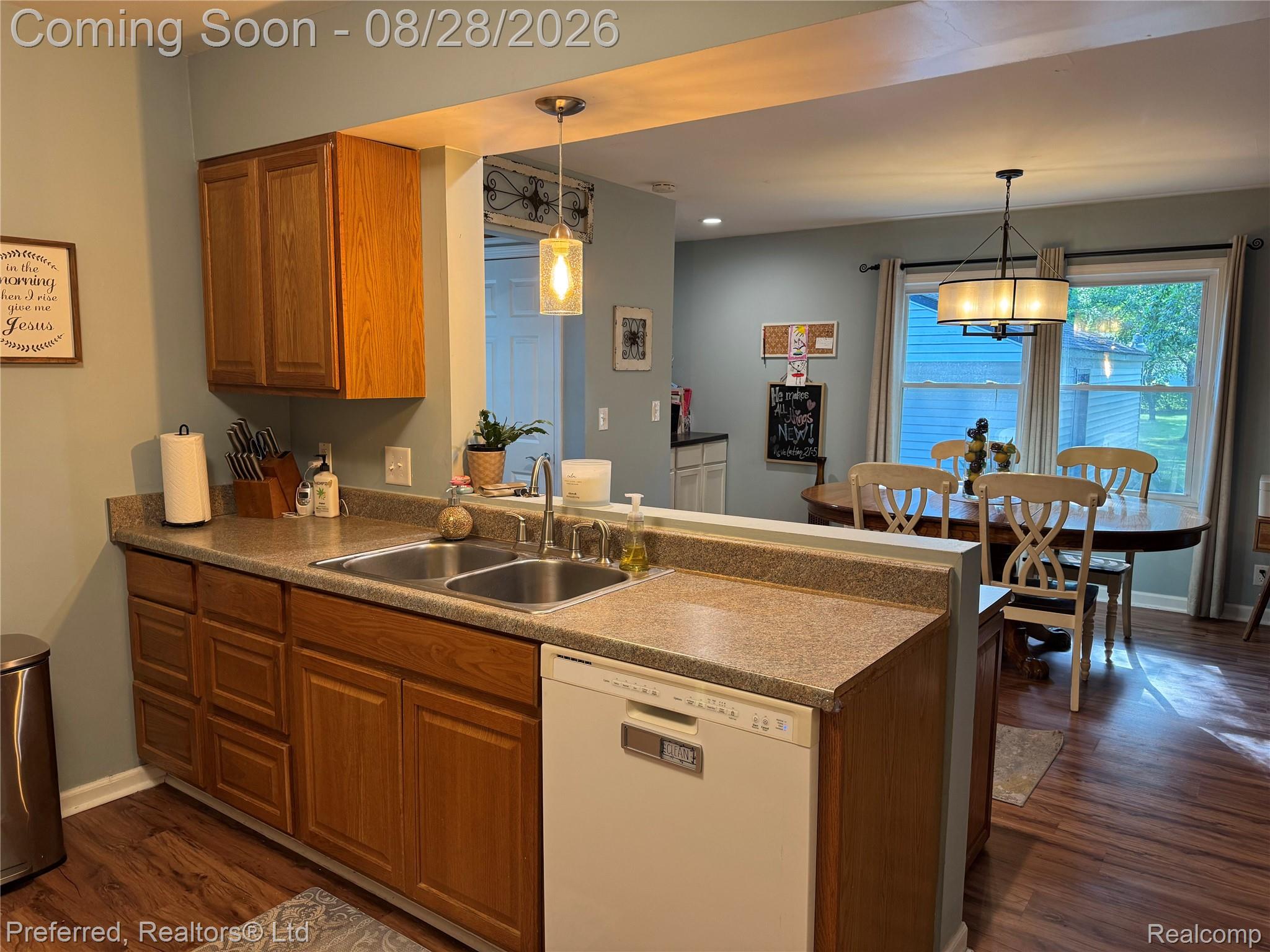 10362 Quirk Road Belleville, MI 48111 - Photo 10 of 41 Kitchen featuring wood-finish cabinetry, a double basin stainless steel sink, and a built-in dishwasher