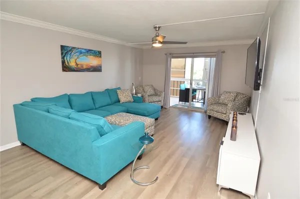 a bedroom with a large bed a flat tv screen and a chandelier