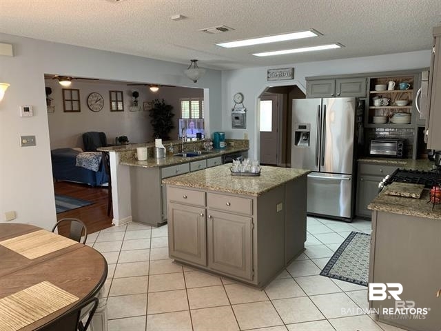 23393 Miflin Road Foley, AL 36535 - Photo 9 of 12 Kitchen with light stone counters, visible vents, arched walkways, a sink, and appliances with stainless steel finishes