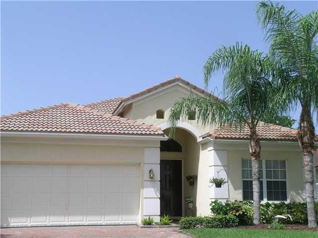 2927 Southeast Racoon Way Stuart, FL 34997 - Photo 1 of 22 a front view of a house with a garden