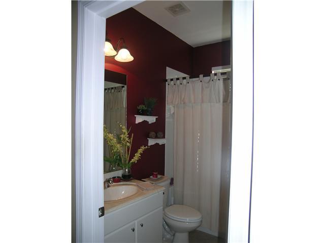2927 Southeast Racoon Way Stuart, FL 34997 - Photo 14 of 22 a bathroom with a toilet a sink and shower curtain