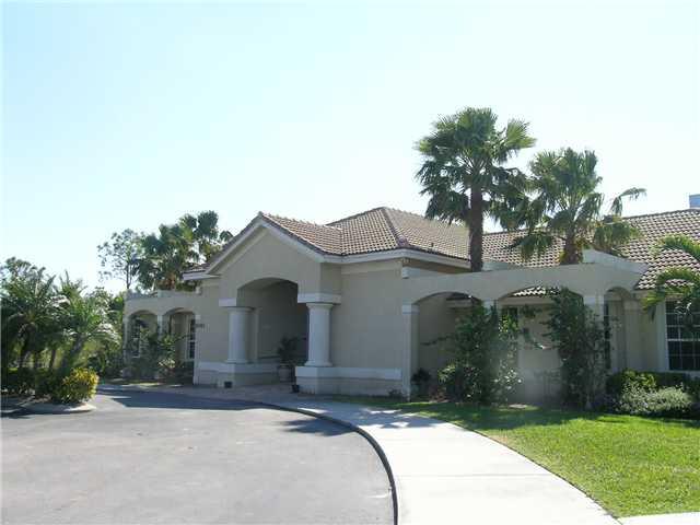 2927 Southeast Racoon Way Stuart, FL 34997 - Photo 18 of 22 a front view of a house with a garden and trees