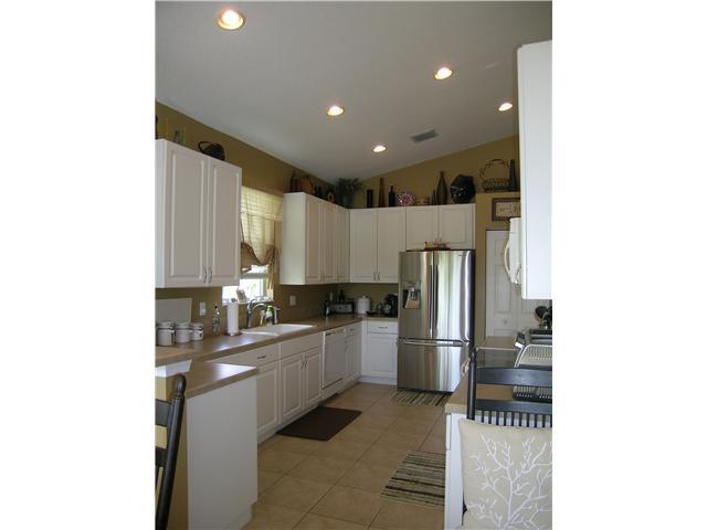 2927 Southeast Racoon Way Stuart, FL 34997 - Photo 6 of 22 a kitchen with stainless steel appliances granite countertop a refrigerator and a sink