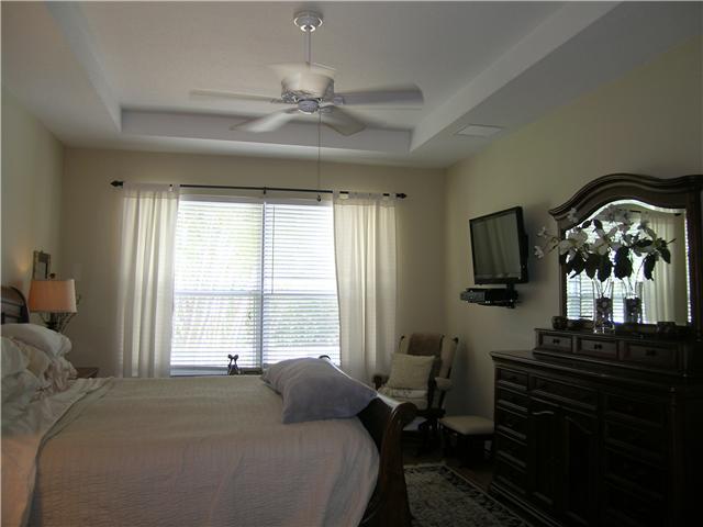 2927 Southeast Racoon Way Stuart, FL 34997 - Photo 8 of 22 a bedroom with a bed and a chandelier