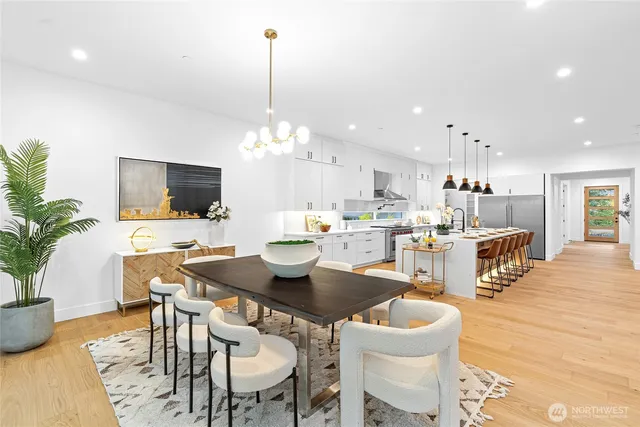 a view of a dining room and livingroom with furniture wooden floor a chandelier