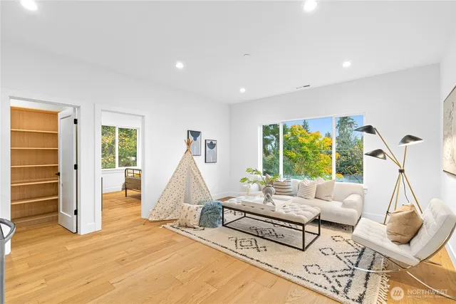 a living room with furniture a wooden floor and a large window