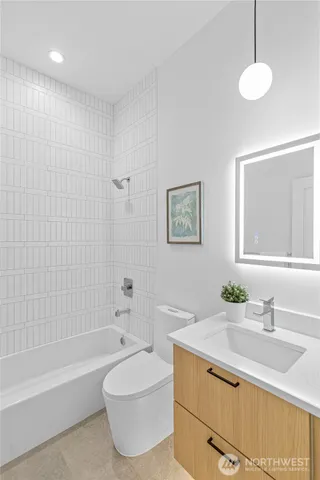 a bathroom with a granite countertop sink a toilet a mirror and bathtub