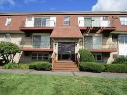 a front view of a house with a garden and plants