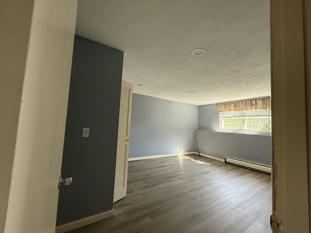 12 Williamsburg Court, Unit 2 Shrewsbury, MA 01545 - Photo 11 of 36 an empty room with wooden floor and windows