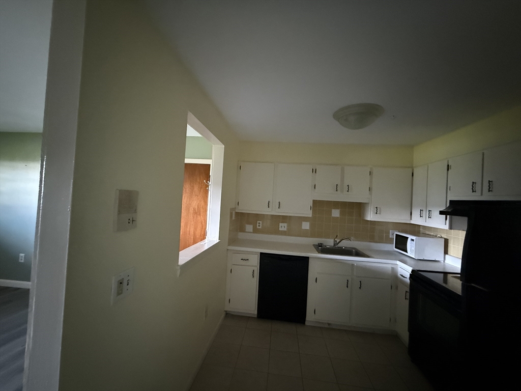 12 Williamsburg Court, Unit 2 Shrewsbury, MA 01545 - Photo 15 of 36 a kitchen with a sink window and cabinets