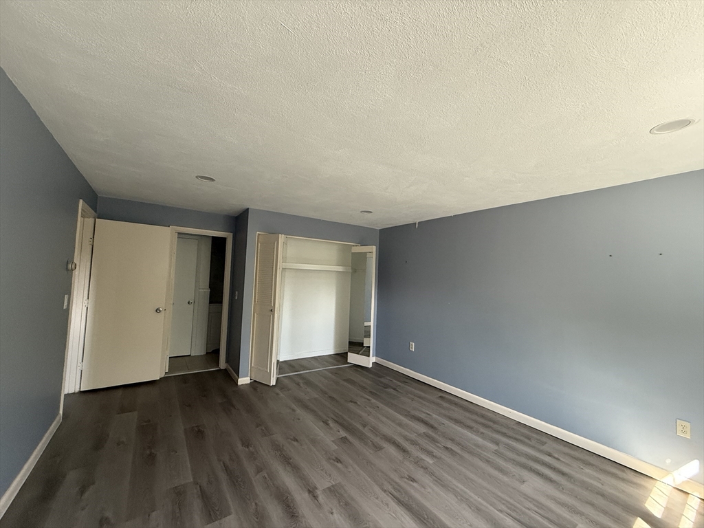 12 Williamsburg Court, Unit 2 Shrewsbury, MA 01545 - Photo 16 of 36 an empty room with wooden floor and windows