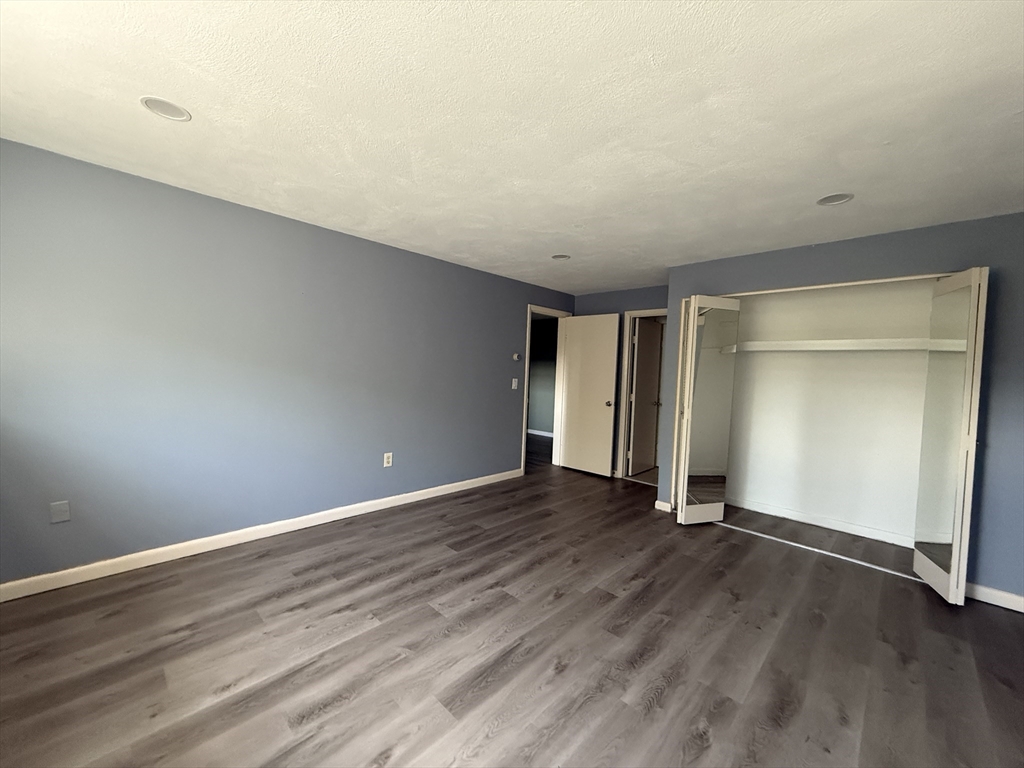12 Williamsburg Court, Unit 2 Shrewsbury, MA 01545 - Photo 17 of 36 a view of an empty room with wooden floor and closet