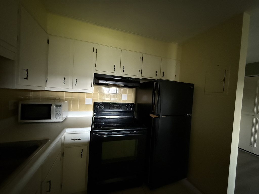 12 Williamsburg Court, Unit 2 Shrewsbury, MA 01545 - Photo 19 of 36 a kitchen with a refrigerator stove and cabinets