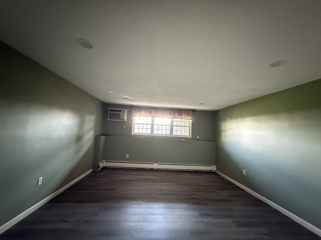 12 Williamsburg Court, Unit 2 Shrewsbury, MA 01545 - Photo 21 of 36 an empty room with wooden floor and windows