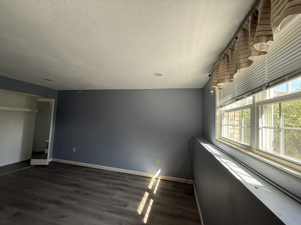 12 Williamsburg Court, Unit 2 Shrewsbury, MA 01545 - Photo 22 of 36 a view of an empty room with wooden floor and a window