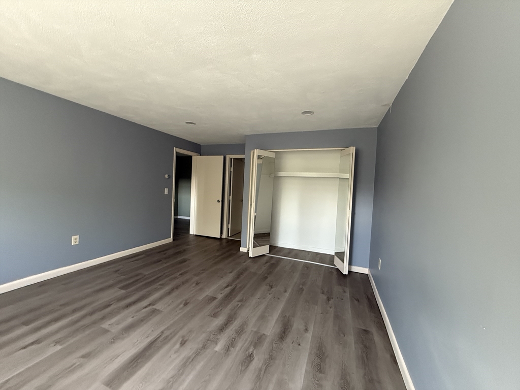 12 Williamsburg Court, Unit 2 Shrewsbury, MA 01545 - Photo 23 of 36 a view of an empty room with wooden floor