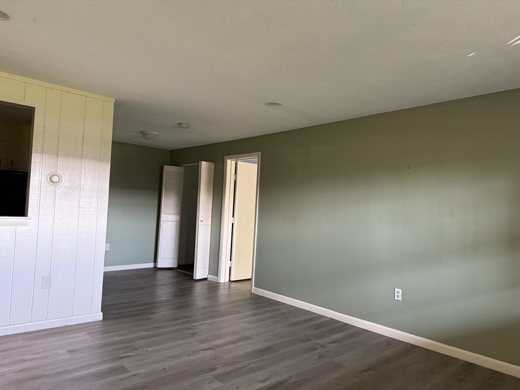 12 Williamsburg Court, Unit 2 Shrewsbury, MA 01545 - Photo 25 of 36 a view of an empty room with wooden floor and closet