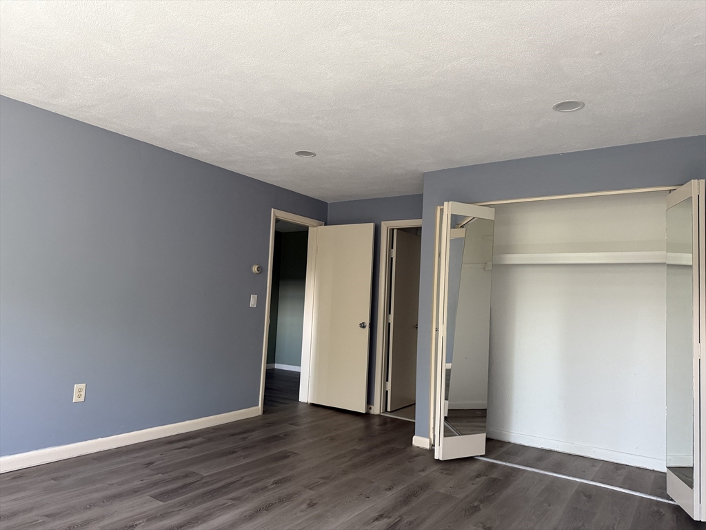 12 Williamsburg Court, Unit 2 Shrewsbury, MA 01545 - Photo 27 of 36 a view of an empty room with wooden floor