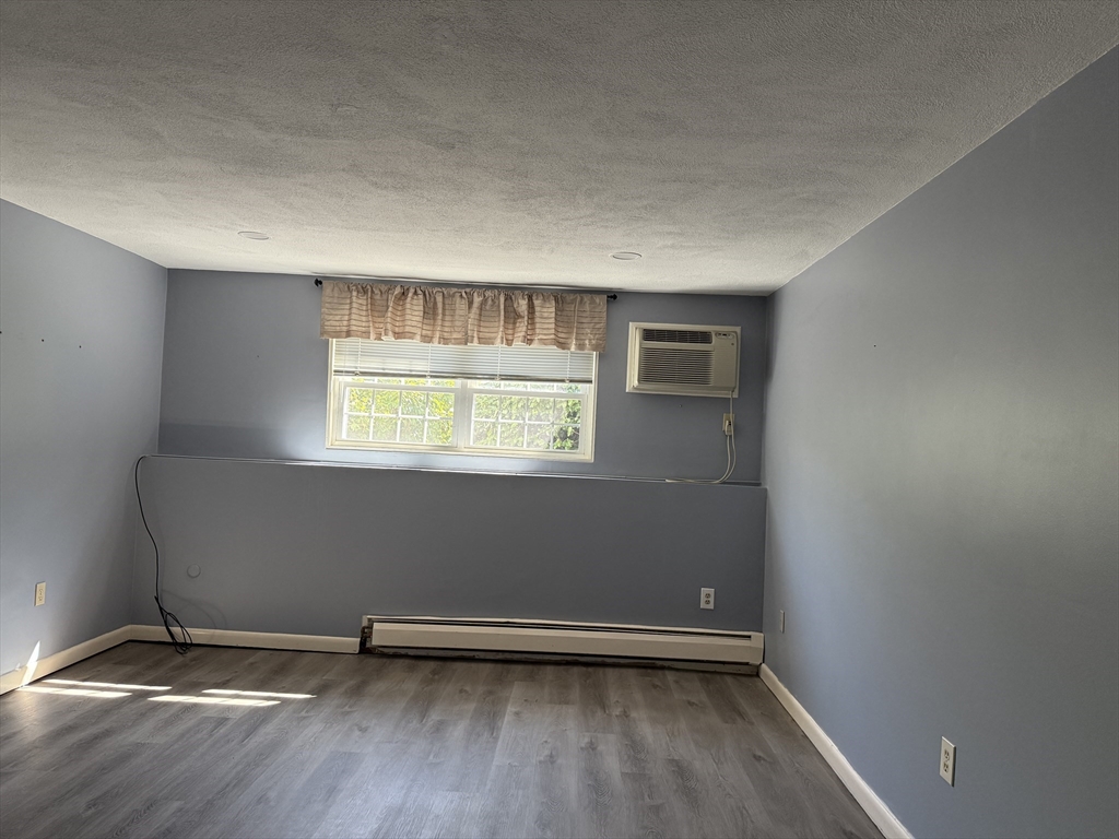 12 Williamsburg Court, Unit 2 Shrewsbury, MA 01545 - Photo 28 of 36 an empty room with wooden floor and windows