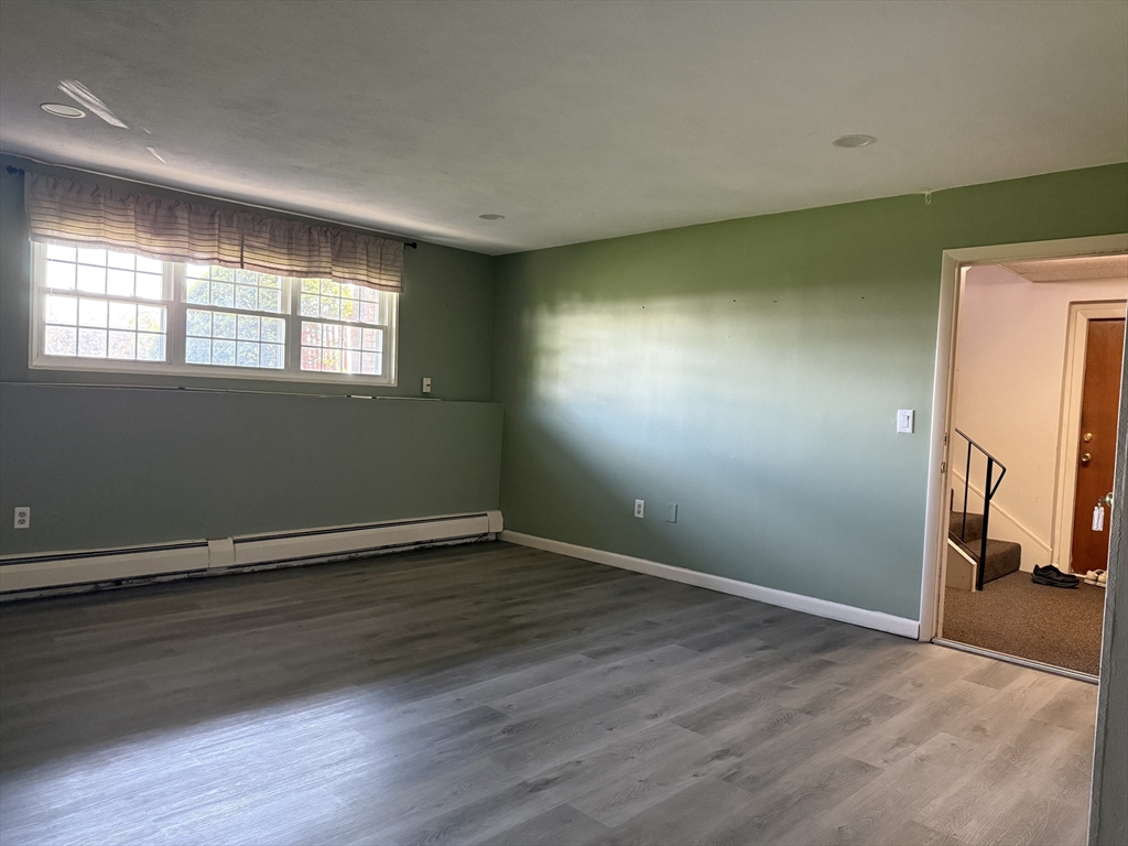 12 Williamsburg Court, Unit 2 Shrewsbury, MA 01545 - Photo 30 of 36 an empty room with wooden floor and a window