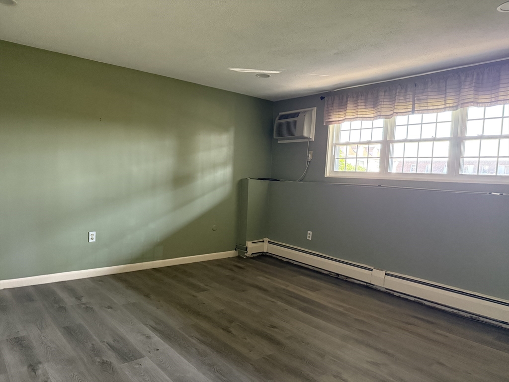 12 Williamsburg Court, Unit 2 Shrewsbury, MA 01545 - Photo 31 of 36 an empty room with wooden floor and windows