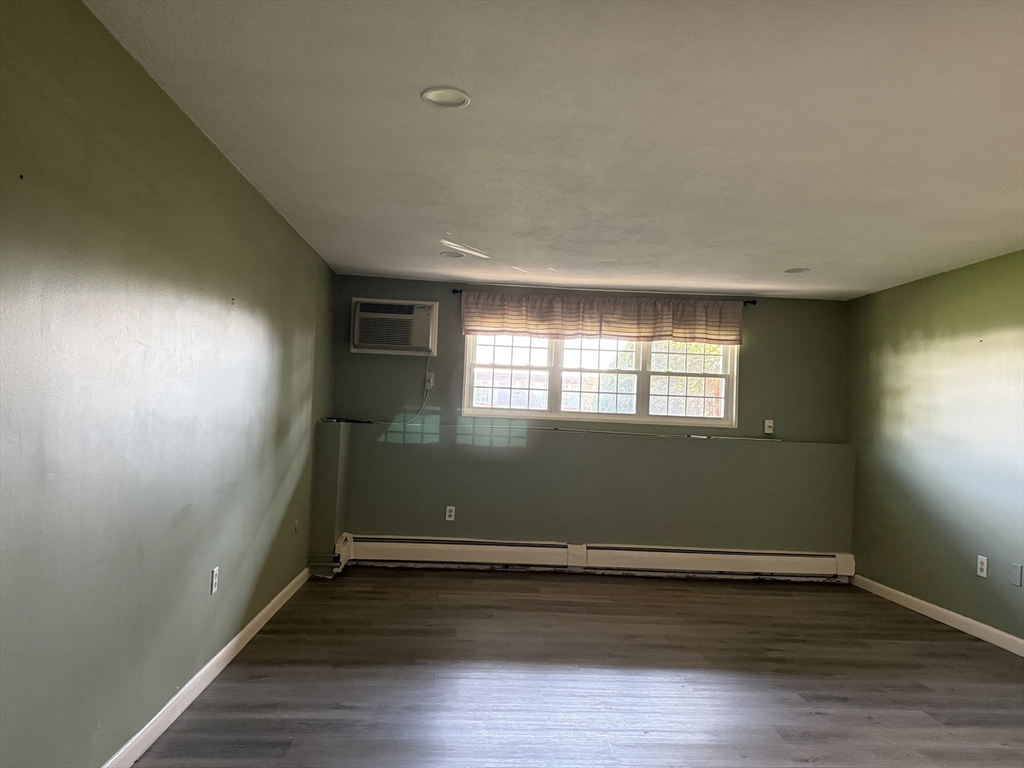 12 Williamsburg Court, Unit 2 Shrewsbury, MA 01545 - Photo 34 of 36 an empty room with wooden floor and windows