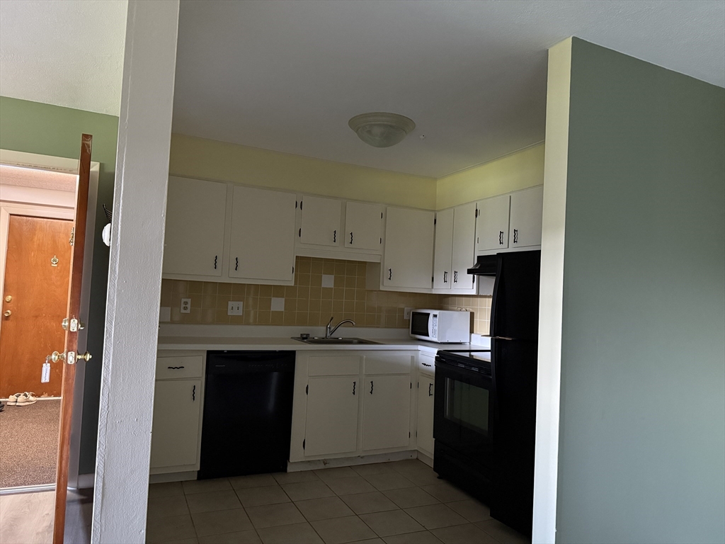 12 Williamsburg Court, Unit 2 Shrewsbury, MA 01545 - Photo 35 of 36 a kitchen with a sink stove and cabinets