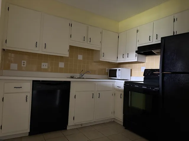 a kitchen with a sink and white cabinets